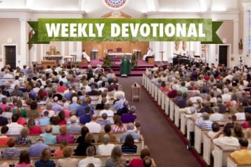 A congregation listening to a sermon under the Weekly Devotional banner