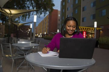 a woman taking classes on her laptop during the evening
