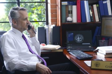 Doctoral education leader speaks on the phone in his office
