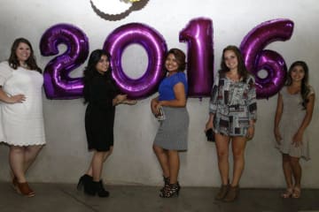 people standing next to 2016 balloons