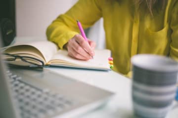 Handwriting, hand writes with a pen in a notebook