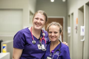 two GCU nurses standing in a hallway