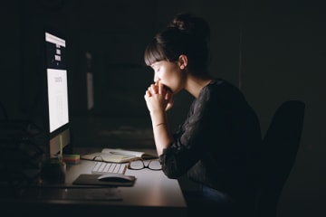 Woman praying and working for the Lord with her computer