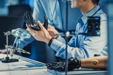 Biomedical engineers with prosthetic arms