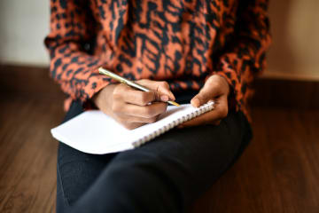 woman writing on notebook