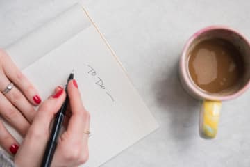 Writing on a piece of paper with coffee nearby