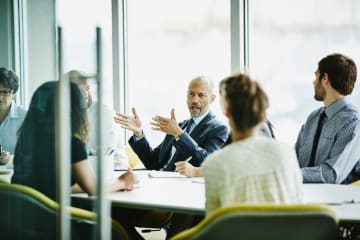 Male business leader with team in conference room