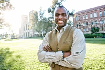 male EdS professor smiling outside of school building