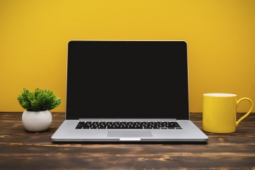 A student's laptop against a yellow background