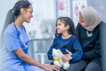 Female FNP talking with young patient and her mom in office
