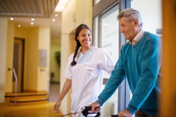 Nurse helping patient walk around hospital safely