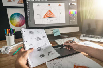 Graphic designer sketching design by hand and digitally