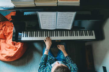 student with music degree playing piano