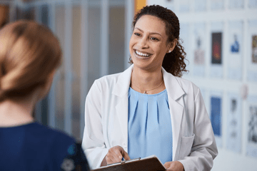 Women's Health Administrator discusses with a patient in clinical setting