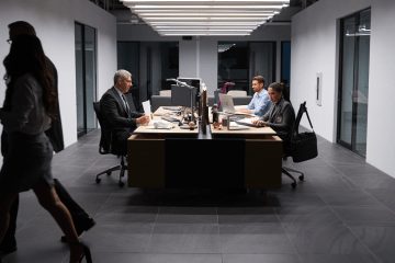 People sit at computers in office meeting setting