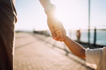 Young child holding parent's hand