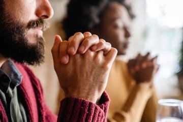 Couple praying before meal as a thankfulness activity