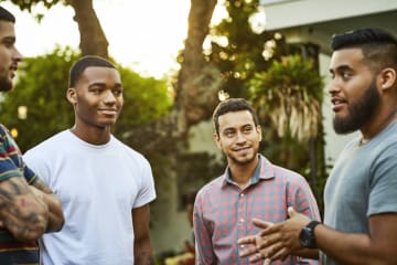 Four men talk with each other