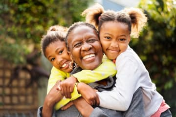 Grandmother and granddaughters showing kindness with group hug