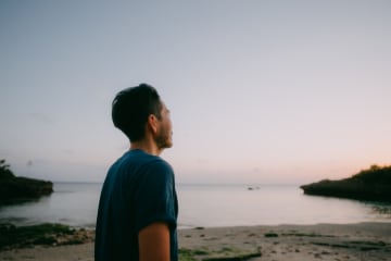 Man looking at the sunset and crying out to God