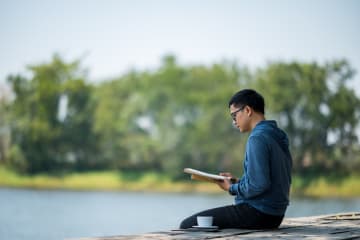 Man reading scripture by lake and making time for God