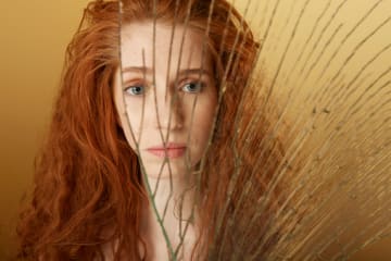 Woman looking in broken mirror