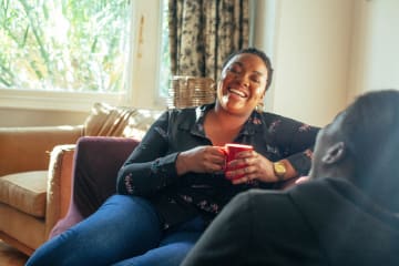 African-American woman having a conversation about faith with friend in a living room