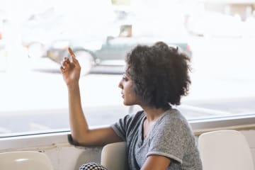 Woman looking out window waiting
