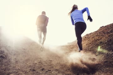 A couple hiking up a dusty mountain
