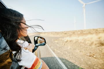Young woman trusting in God's promises and smiling in car