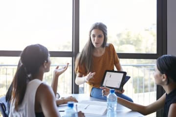 Female teacher working with young adult students in classroom