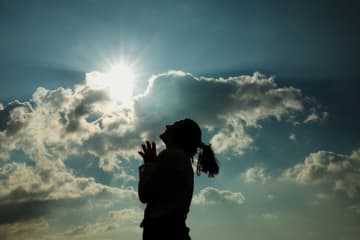 Silhouette of Woman Praying at Sunset