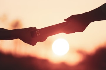 Person gives a Bible to another person