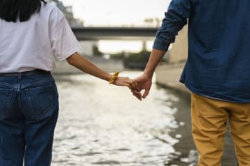 Couple holding hands by river