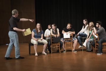 Students engage in a group activity in a theatre class setting