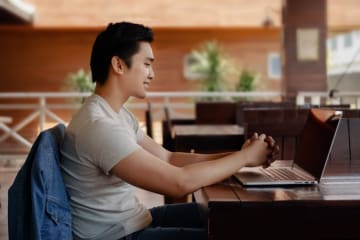 a high school student sitting at a desk attending class online