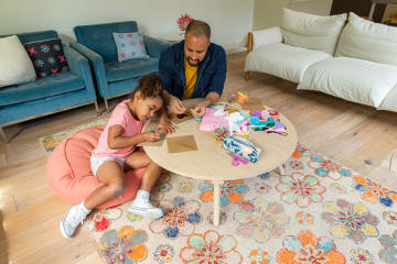 a child and her father doing crafts together