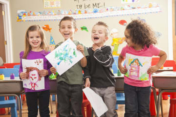 preschool children displaying their artwork