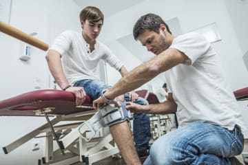 physical therapist looking at a patient's knee