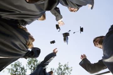 college graduates throwing caps
