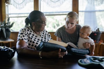 Two women and a baby reading the Bible 