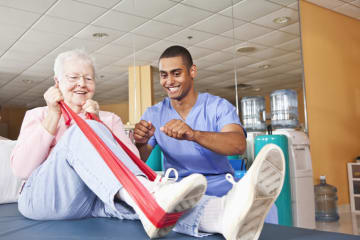 physical therapist helping a patient stretch during a session