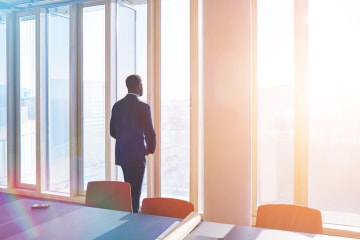 business person staring out of a window contemplating their stewardship