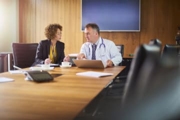 healthcare professional working with a colleague in a meeting room