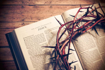 Gospel of John open with crown of thorns on top of it