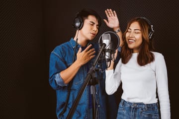 Male and female session musicians singing together in studio