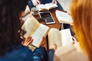 Students reading books for their book reviews 