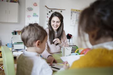 Female teacher showing children the benefits of rubrics