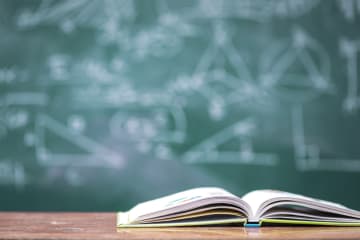 A book in front of a chalkboard 