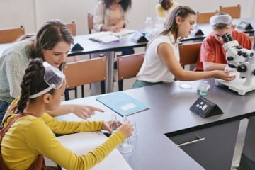 Science class teacher helping student in classroom